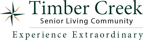 Logo of Timber Creek Senior Living Community featuring a star design on the left. The text reads "Timber Creek Senior Living Community" and "Experience Extraordinary" below.