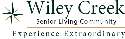 Logo of Wiley Creek Senior Living Community. It features a compass symbol on the left with the text "Wiley Creek Senior Living Community" and the slogan "Experience Extraordinary" below it.