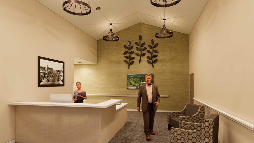 A reception area with a counter and a person standing behind it. A man is walking through the room. The walls are decorated with leaf motifs and a framed photo. Two patterned chairs are placed on the right side. Three pendant lights hang from the ceiling.